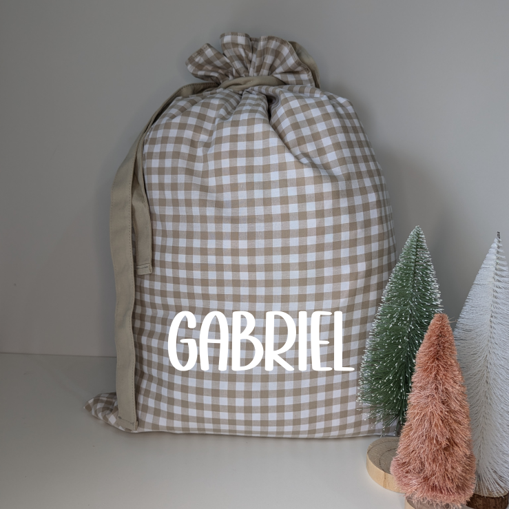 Gingham personalised Santa sack for Christmas. Custom name decal Santa sack. White and beige. Festive gifts. Neutral Christmas theme.