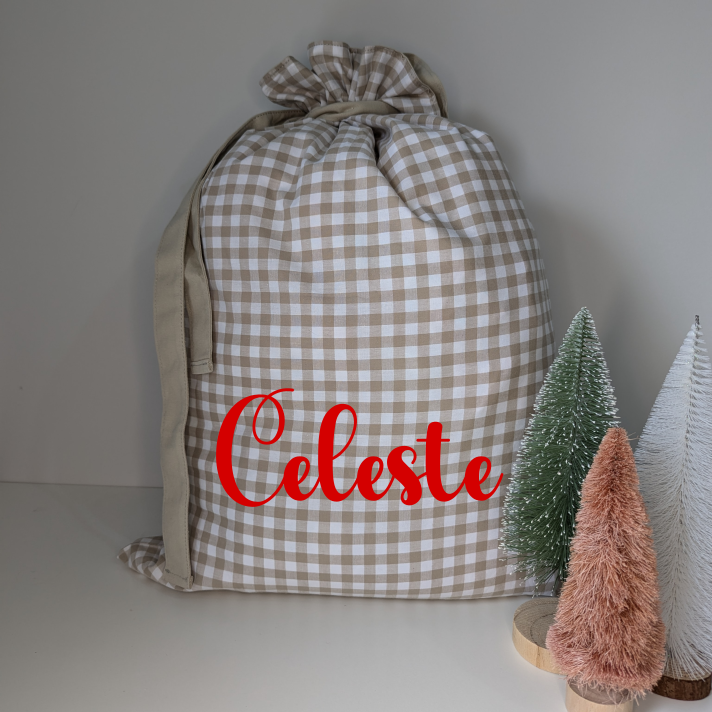Gingham personalised Santa sack for Christmas. Custom name decal Santa sack. White and beige. Festive gifts. Neutral Christmas theme.